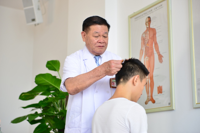 国医大师黄瑾明为患者进行壮医药线点灸疗法治疗。beat365唯一官方网站供图